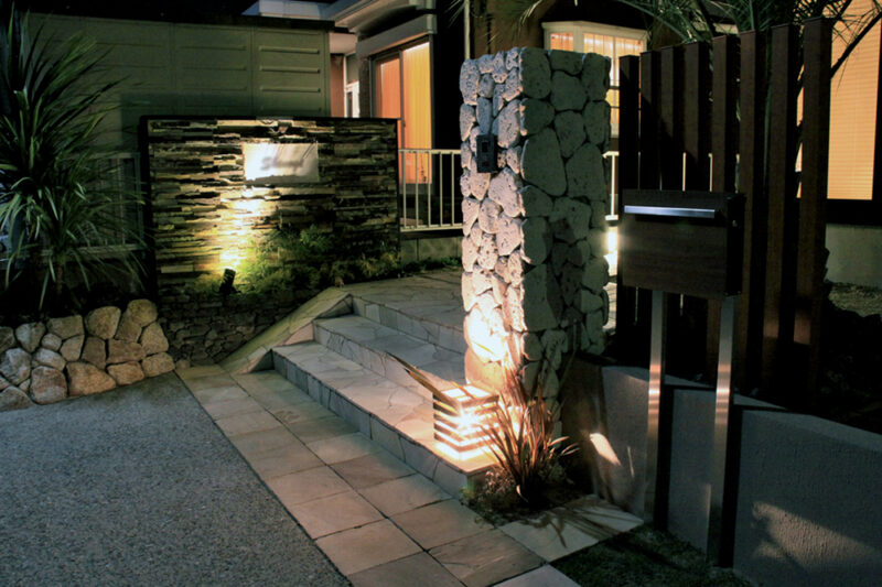 琉球石灰岩を使った門柱の足元には、ハードウッド材でつくったオリジナルの照明。