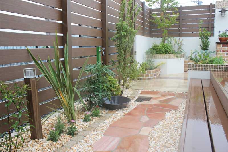 木調フェンスと飾り壁、そこに植栽を組合せることにより圧迫感のないやさしい雰囲気に。