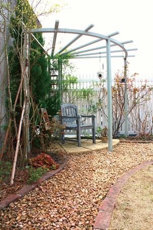庭の奥のパーゴラコーナー。コンクリートの擁壁を植栽とパーゴラコーナーで演出し、やわらかい雰囲気に。