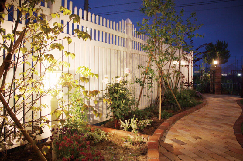 高級感あふれる白いフェンスと植栽をやさしい明りで演出したナイトガーデン。