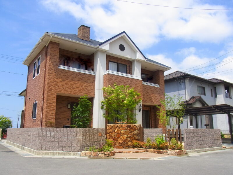 外構全景。自然石と緑が青空に映える。