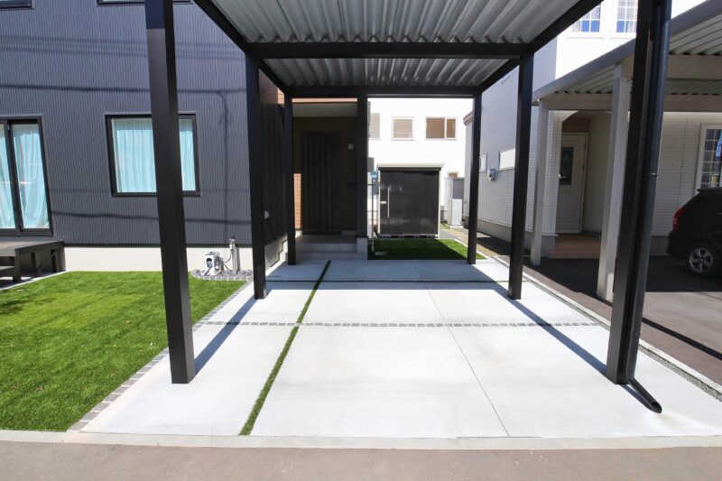 アクセントとしてデザインした人工芝の目地が玄関までの動線を誘導してくれます。ブラックのピンコロが床の白さを引き締めてカッコイイデザインとなりました！