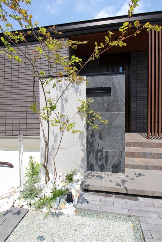 ２色のタイルで魅せるシックな佇まいの門柱にアオダモの樹形がマッチします
