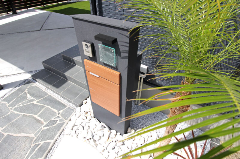 宅配ボックスを兼ね備えたダークカラーの門柱は建物と調和します